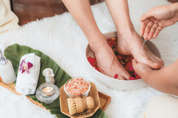Woman indulges in blissful foot massage at luxurious spa salon while masseur give reflexology therapy in gentle day light ambiance resort or hotel foot spa. Quiescent