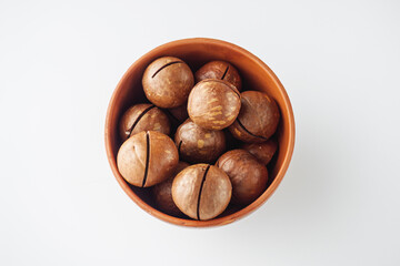 macadamia nuts in bowl on white background