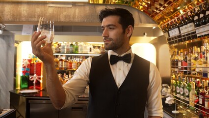 Smart bartender chilling glass with ice for serving drink to customer at beverage bar counter welcome drink with charm professionalism making great first impression greeting guess at club. Vinosity.