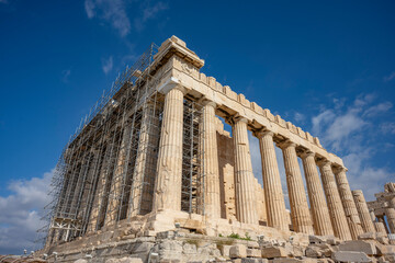 Obraz premium Architectural masterpiece, the Parthenon, a unique UNESCO world heritage archaeological site of Acropolis hill with beautiful scattered clouds and deep blue sky, Athens historic center, Attica, Greece