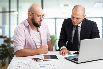 Two happy professionals business partners checking document