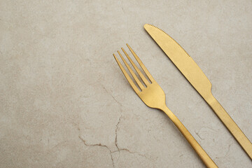 Set of golden metal cutlery on stone table