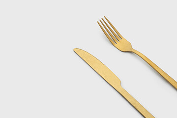 Set of golden metal cutlery on white background