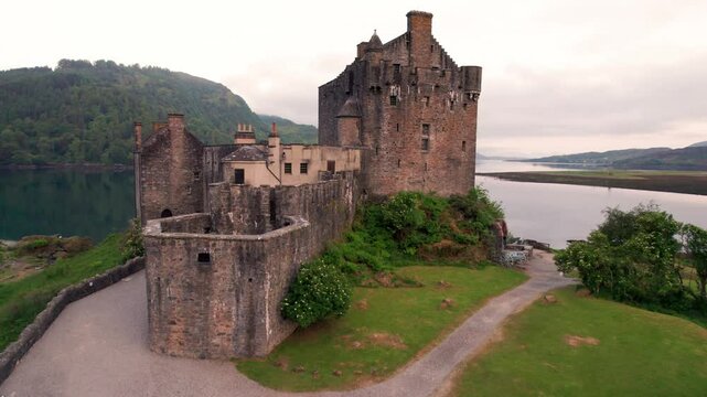 Epic Aerial Eilean Donan Castle Scotland with Moat Flies From Wide Over the Top, Just Barely Missing it at Sunrise