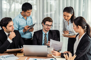 Diverse of business people from various ethnic group working in modern office environment. Productive and multi ethnic office workers engage in discussion for strategic business marketing. Meticulous