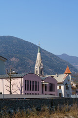 Brixen's Iconic Church Steeple with Modern and Historical Architecture in Alpine Setting