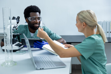 Obraz premium Colleagues scientists diligently working in modern laboratory using microscope and laptop