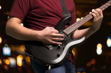 Bassist's music man hands playing on guitar
