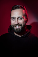 Portrait of a Man Smiling Under Dramatic Red and Black Light..
