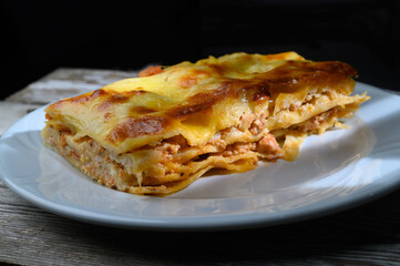 Delightful homemade lasagna layered with rich cheese and savory meat on a rustic wooden table