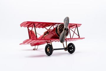 Avión biplano clásico pintado de rojo, de hélice, aislado en blanco