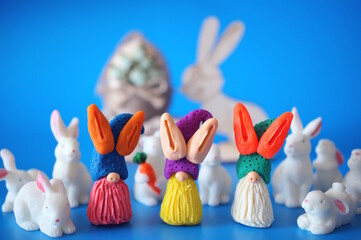 Three colorful Easter gnomes and toy bunnies. Decorations for Easter.