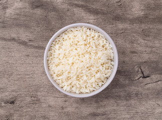 Cooked white rice in a bowl over wooden table