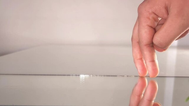 Girl running her fingers on edge of glass Isolated on White Background