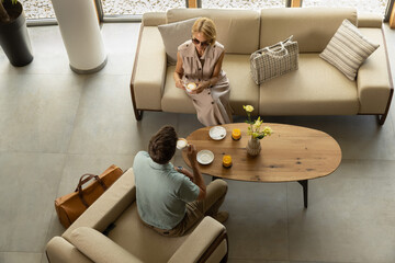 Couple relaxing with coffee at hotel, top view
