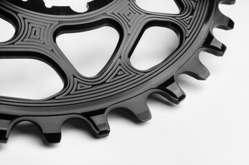 Close up of a black oval bicycle chainring against white isolated background. Professional bicycle part.