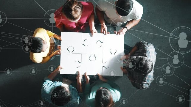 Top down view of business people gathering jigsaw together at meeting. Aerial view of diverse team collect or put piece of white puzzle together with computing global networking community. Symposium. - Powered by Adobe