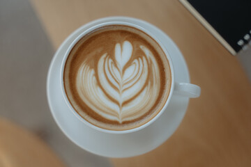 Latte Art Delight: A beautifully crafted latte featuring intricate art, the creamy beverage sits elegantly on a saucer, inviting you to savor the moment.