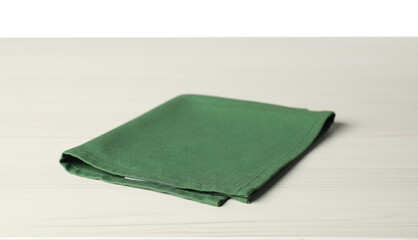 Green napkin on light wooden table against white background