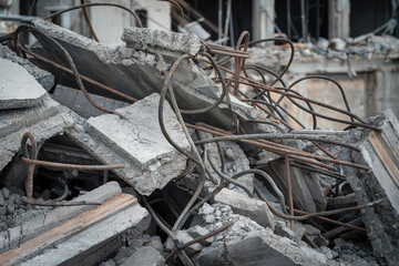 Concrete debris and bent rebar piles at a demolished construction site in an urban environment
