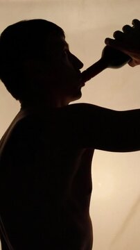 silhueta de homem bebendo em garrafa 