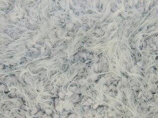 Closeup of light gray fluffy synthetic knitting background. Frosty winter concept. 