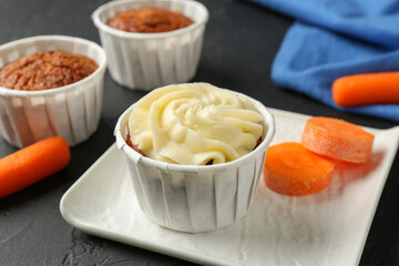 Delicious carrot muffins with fresh vegetable on grey table, closeup