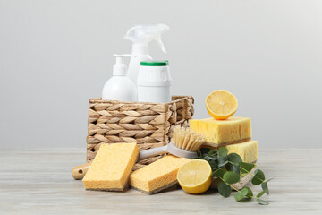 Eco-friendly cleaning products, supplies and eucalyptus branches on wooden table