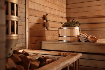 Bucket, whisk, ladle and towels on wooden bench in sauna