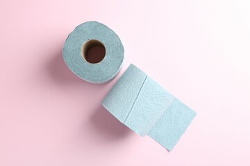 Blue toilet paper rolls on light pink background, top view