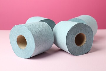 Blue toilet paper rolls on pink background