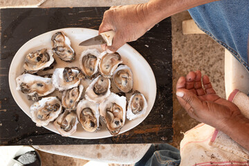 Hands of a man opening oysters