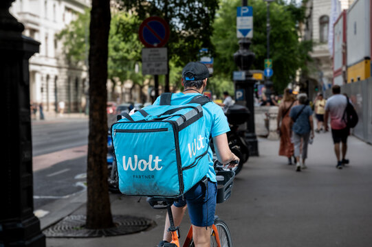 Budapest, Hungary, August 30, 2022. A worker at wolt, a food delivery company. The blue bag with the white logo is highlighted. Lifestyle of food distribution and consumption in the city.