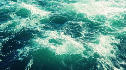 Turbulent blue and green ocean waves in bright sunlight
