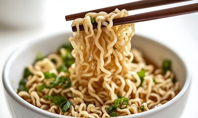 Close Up of Chopsticks Lifting Noodles from Broth in White Bowl