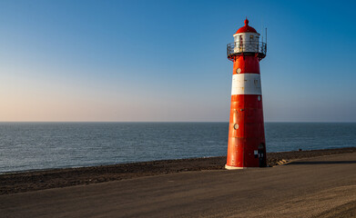 The red and white lighthouse Noorderhoofd at the Dutch coast near Westkapelle, Province of Zeeland,...