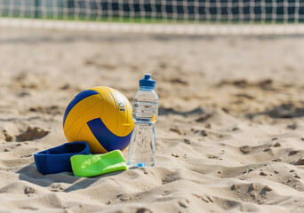 Volleyball, water bottle, and wristbands lie on the sand of a beach volleyball court, net in background, suggesting a refreshing pause during a sunny game
