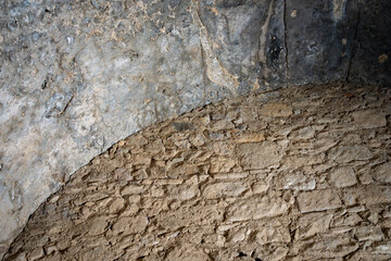 Ancient wall constructed of rock and mortar shaped with a curve and flat stone wall