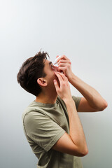 Man is using eye drops for allergy treatment. Man drips eye with eyes drops due to irritation...