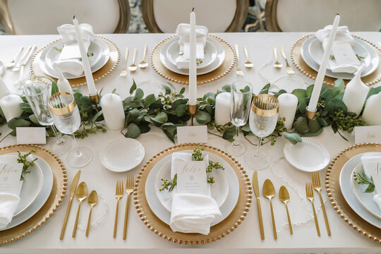 Elegant dining table setting with greenery and candlelight for a special occasion