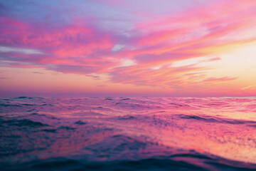 Vibrant sunset over tranquil ocean water reflecting colorful sky hues near horizon