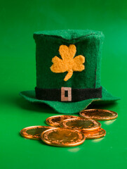 leprechaun hat and coins on green background