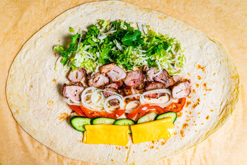 Delicious burrito preparation with fresh ingredients in a kitchen