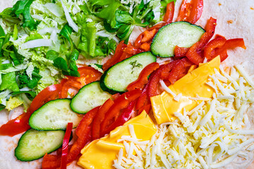 Colorful ingredients arranged for a fresh wrap preparation