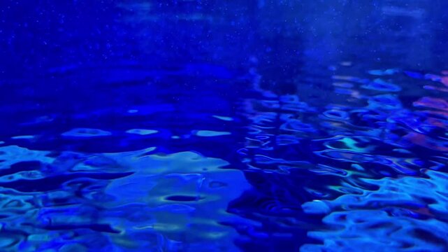 A video of an underwater blue current water for a tranquility or fresh pool or aquarium background concept.