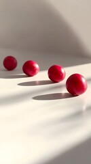 Crimson spheres in sunlight: Four vibrant crimson spheres cast elongated shadows against a simple background, bathed in the soft glow of natural light, minimalist and artistic.