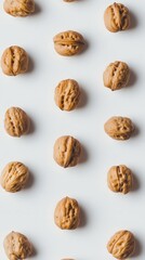 Walnut Pattern:  A minimal composition featuring whole walnuts arranged in a vertical pattern on a smooth, light surface, creating a visually appealing and balanced design. 