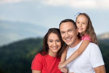 Obraz premium Happy young family with children at nature park background
