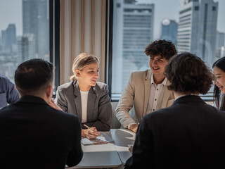 Diverse group of businesspeople collaborating in a boardroom meeting, working together on corporate strategy and planning.