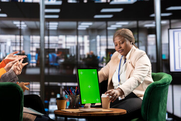 Obraz premium Diverse group of female colleagues ensuring goals achievement next to chroma key display, believing in equal rights and women empowerment. Powerful businesswomen work with resilience.